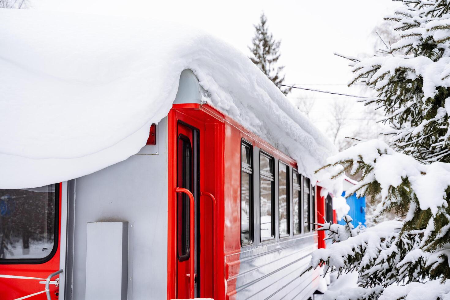 A close-up of the train car is shot. Winter photo at the train station. The red color of the train.