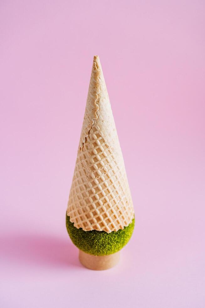 Ice cream cone with a lawn ball. An unusual ice cream with a ball from the lawn stands upside down. Abstract shot of food and greenery photo