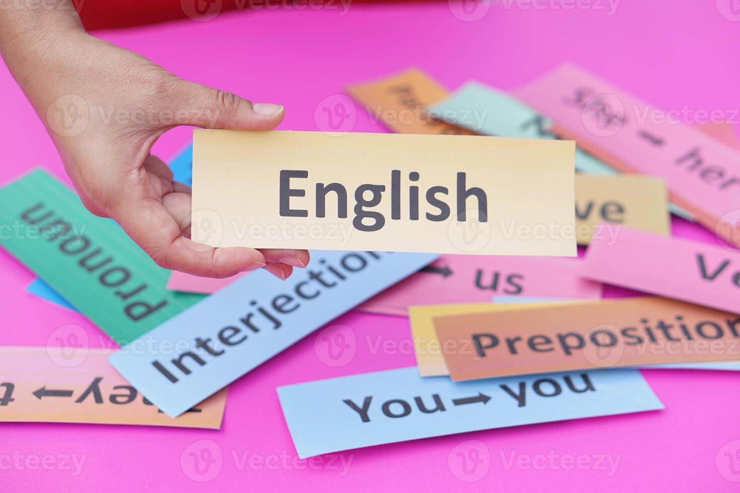 Close up hand hold paper card with text English. Concept, English language teaching. Using word card to create for playing educational fun games or practice lesson. photo