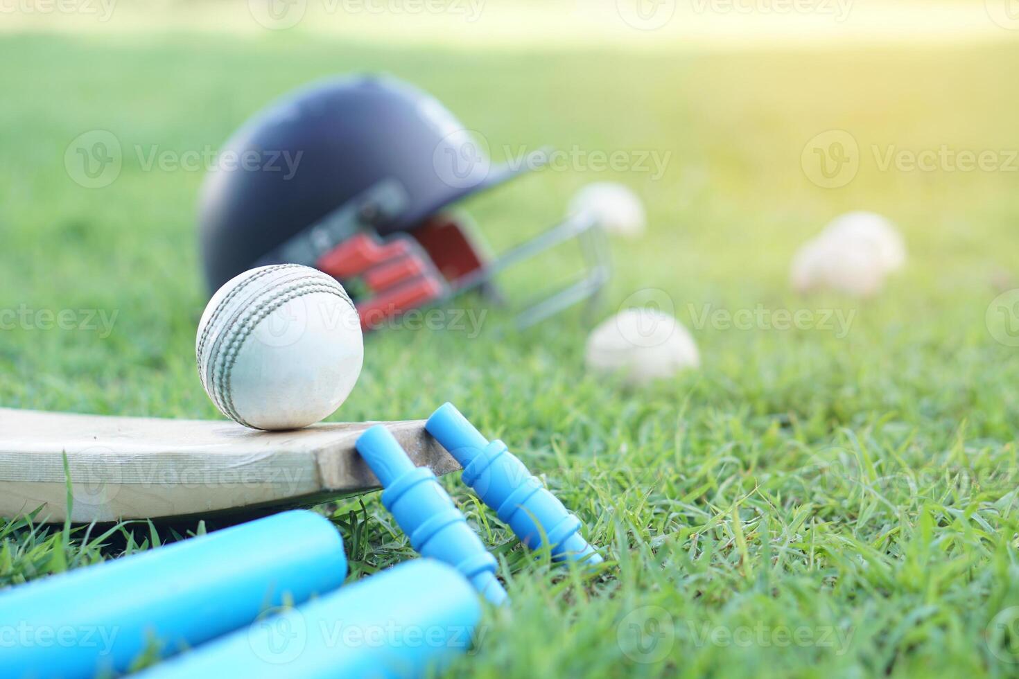 White cricket ball on wooden racket. Concept, sport equipment. Competitive sport. A cricket ball is made with a core of cork, covered by a leather case with a slightly raised sewn seam photo