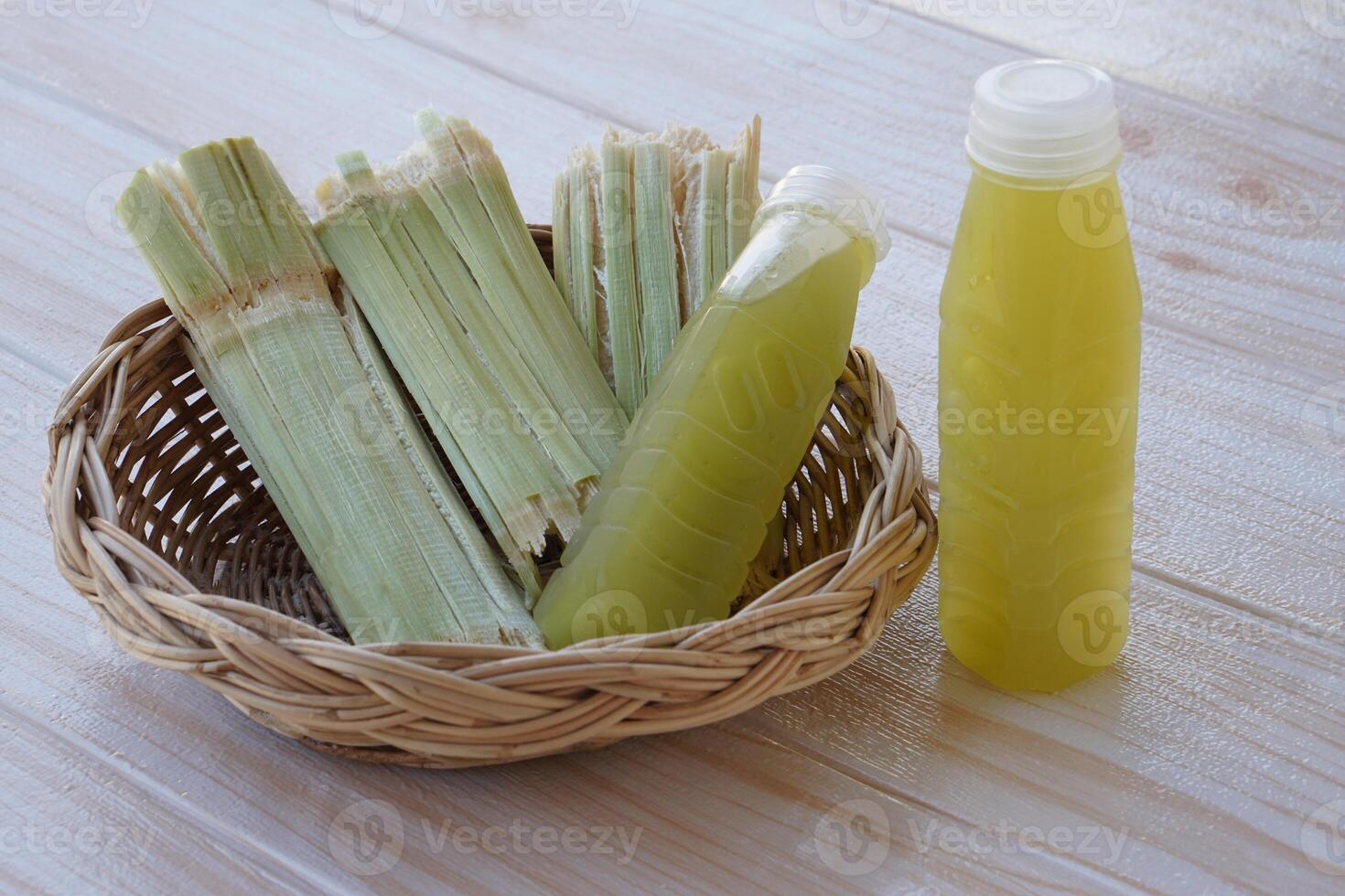 Bagasse after squeezing for a drink in basket and bottles of fresh sugar cane juice. Concept, healthy natural beverage made from agriculture crop. Homemade drinks, has medicinal and herbal photo
