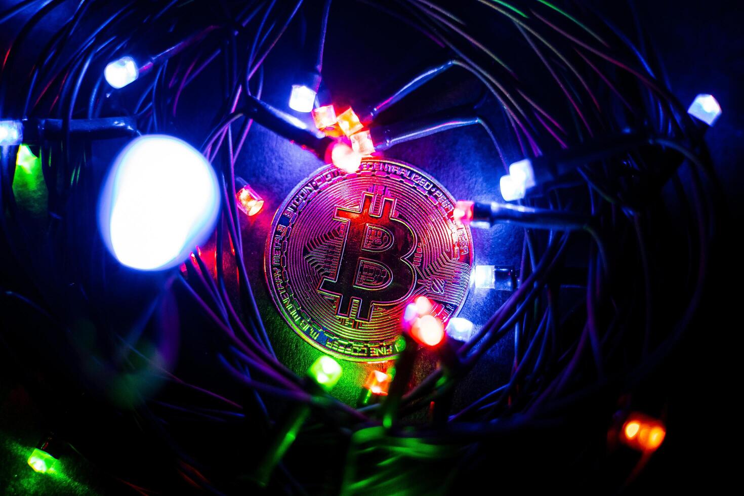 Bitcoin coin lies among the New Year's garlands. Souvenir coin. Digital money in the modern world. The growing market of electronic money photo