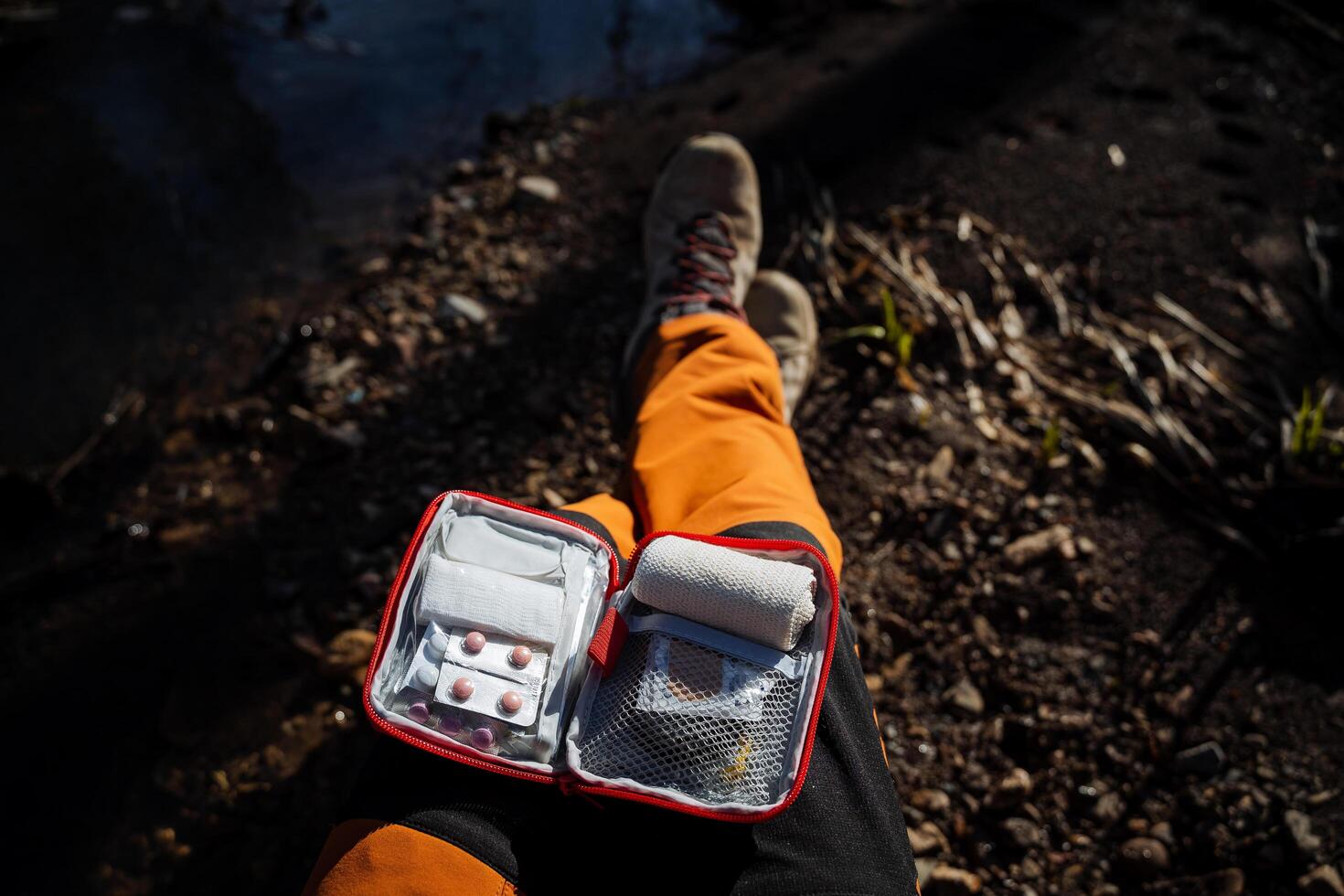 el primero ayuda equipo es abierto en tu regazo, el ver desde encima en el equipo de drogas para primero ayuda, medicamentos son doblada dentro un pequeño bolsa, tabletas, vendajes foto