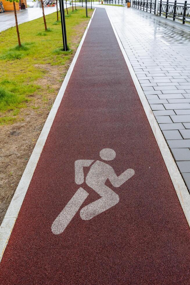 Treadmill in the city park, badge for running on asphalt, designation of a place for training runners, soft coating for legs, pavement line, photo