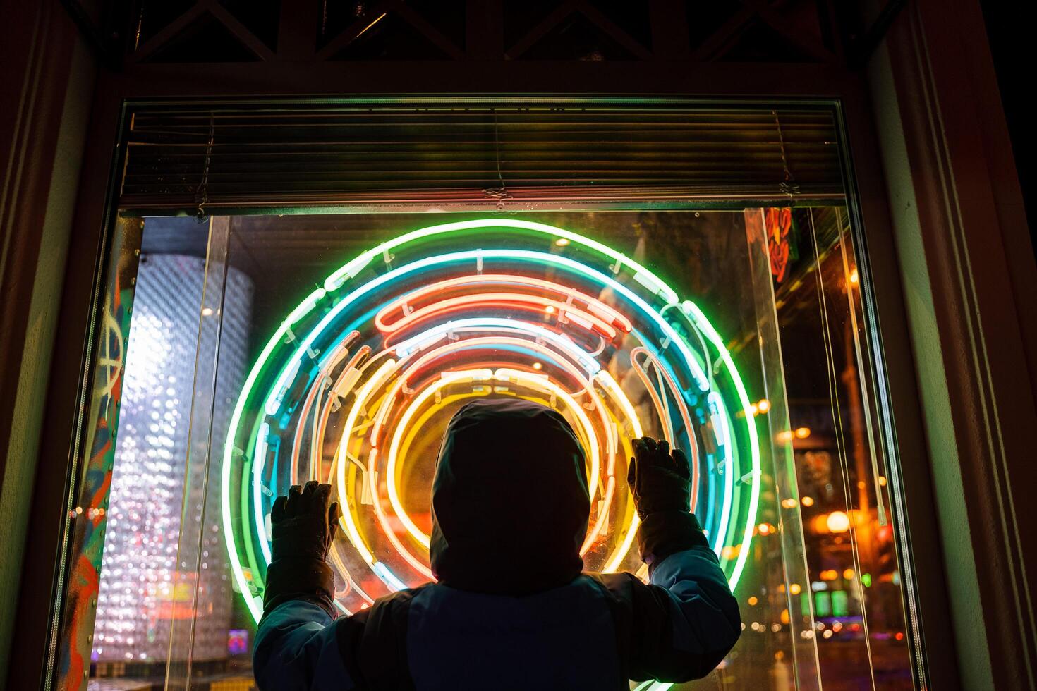 Silhouette of a person's hand to the sides against a background of colored circles. Silhouette at night in the city. photo