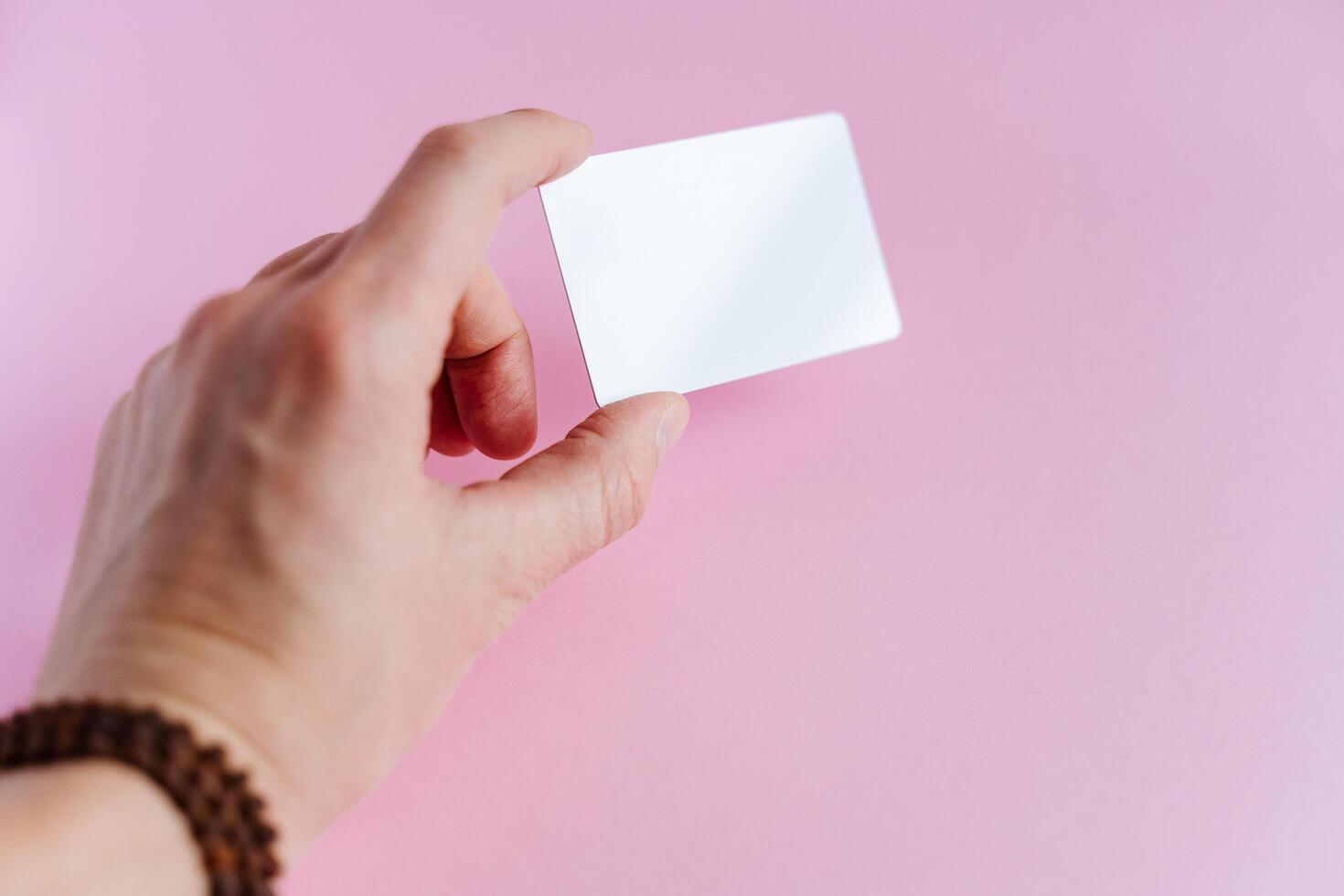 In the hands of a white empty business card, a business card for a company or person. Information in a compact form. Advertising on a business card photo