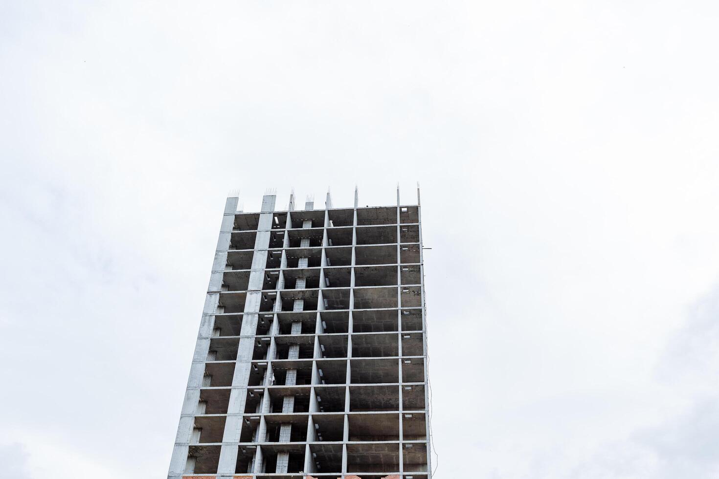 High-rise building made of concrete, apartment building, construction of a residential building, concrete floors, lack of windows, solid construction, reinforced concrete frame. photo