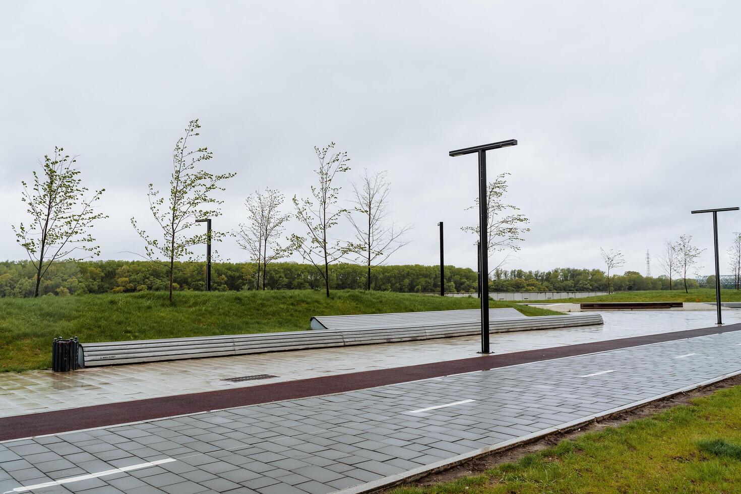 bicicleta camino en el ciudad parque, banco para relajación, paisaje diseño de urbano espacio sitio para caminando, cortado césped verde césped, poste de luz diseñador foto