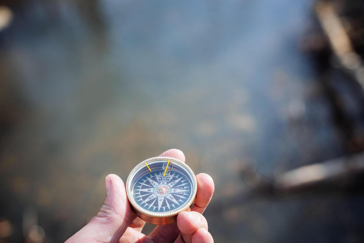 Compass vintage is shot close-up, the arrow shows north, orienteering on the terrain in the forest. Cardinal directions, magnetic pole. photo