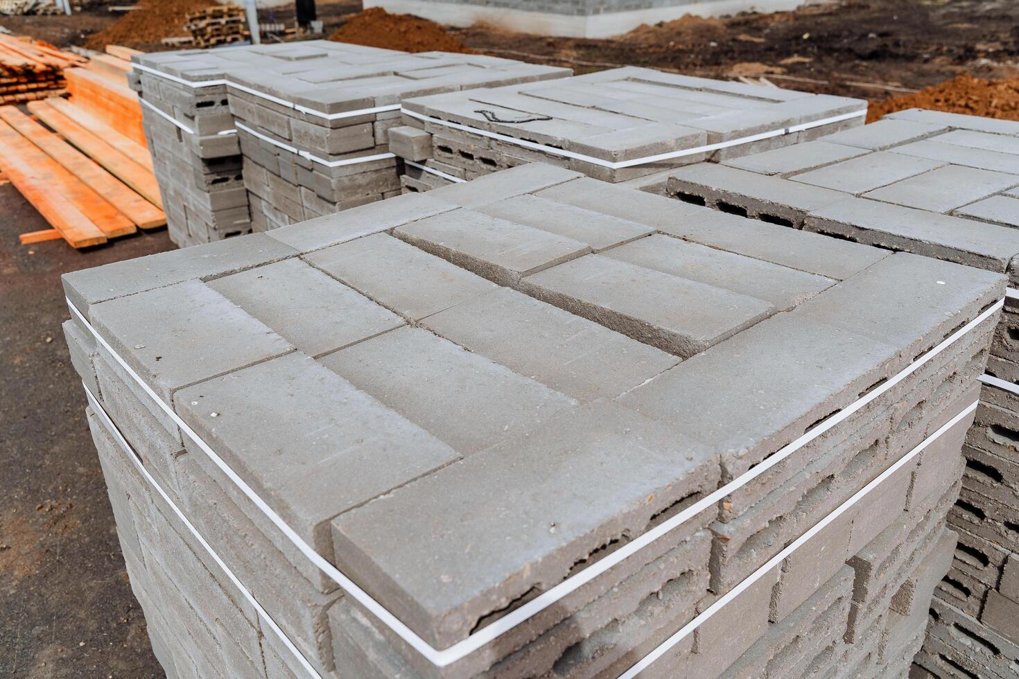 Packing of concrete bricks in a heap, screed with white tape, cement blocks for building a house, suburban construction, warehouse storage of building materials. photo