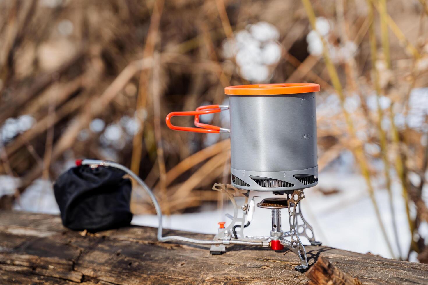 The pot stands on the gas burner, cooks food on a hike, cooks soup, boils water on a tourist burner, camping gas, breakfast in the forest, travel equipment photo