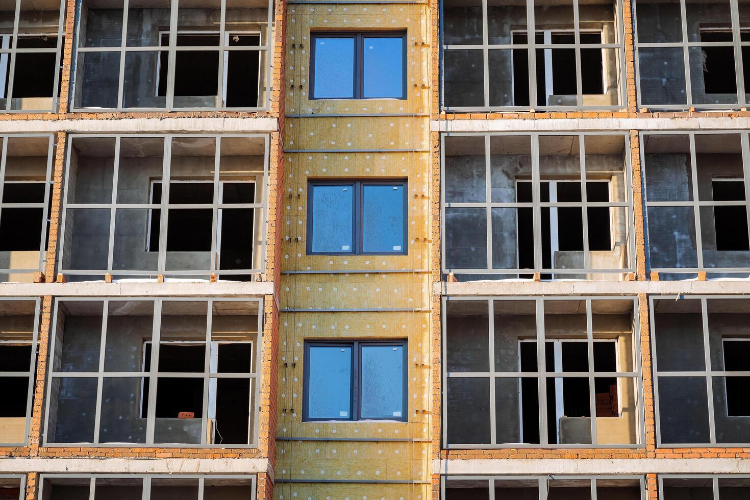 Insulation of the building with mineral wool outside. Protection of the house from the cold, noise insulation of the residential townhouse. Construction of an apartment building. photo