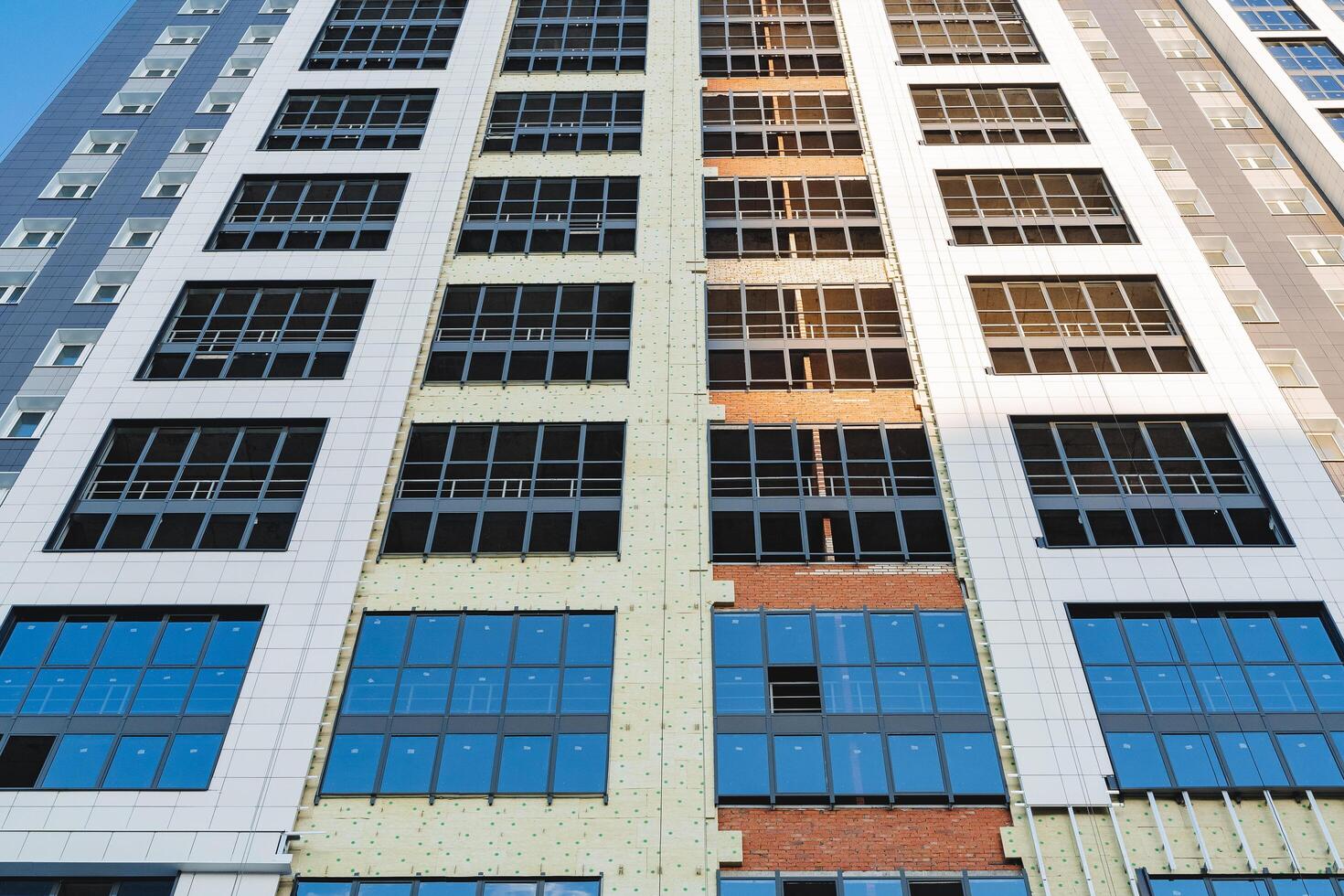 Installation of double-glazed windows in a residential building, the facade of the house of the construction site, an aluminum frame without glass, the construction of a high-rise building photo