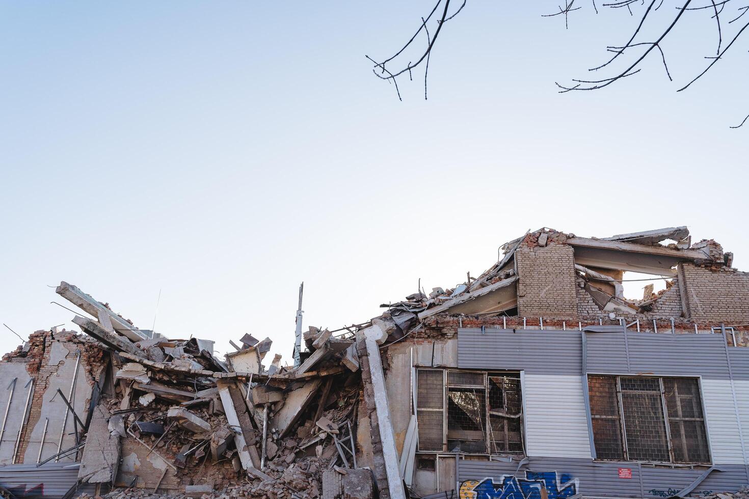 A ruined house against a blue sky. The explosion destroyed the building, demolished the house a bunch of concrete. The consequences of the disaster, the earthquake. photo