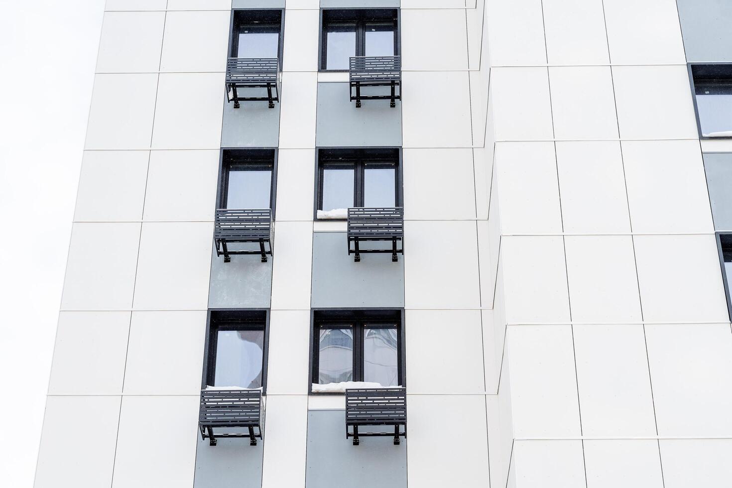 Facade of an apartment building. Housing in the city. Modern materials for finishing houses. Air conditioning under the windows of each apartment photo