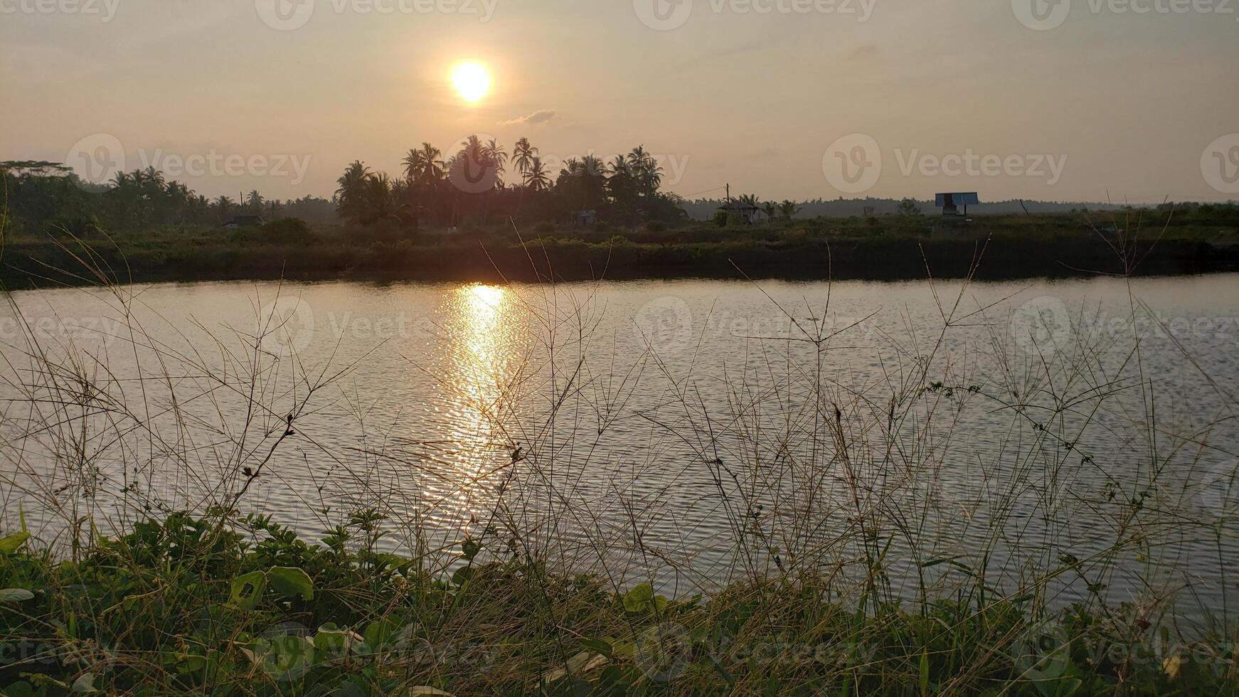 The sunset can be seen in the afternoon and you can see its reflection in the pond water, the light is really very beautiful photo