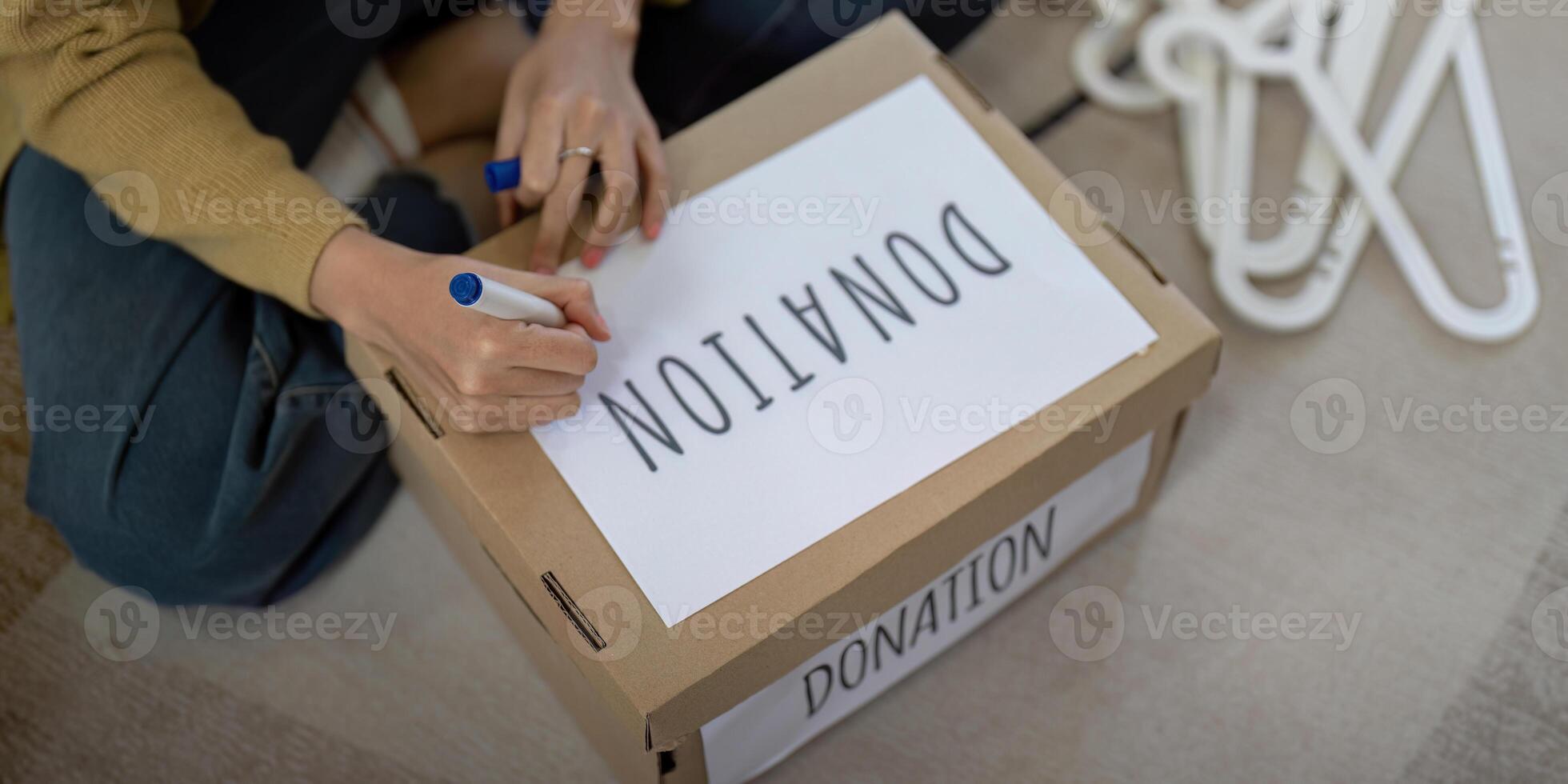 Woman asian preparing a delivery box with her used clothes, Donation and recycling concept photo