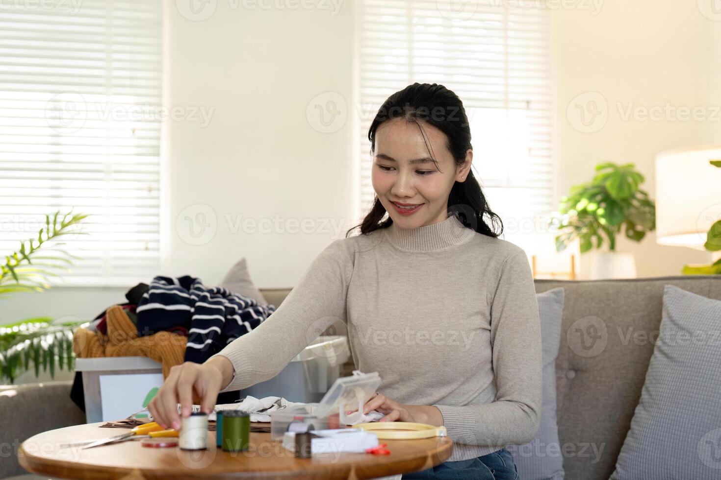 Woman repairs sews reuses fabric from old clothes economical reuse. DIY Hobby Reuse Recycling at home photo
