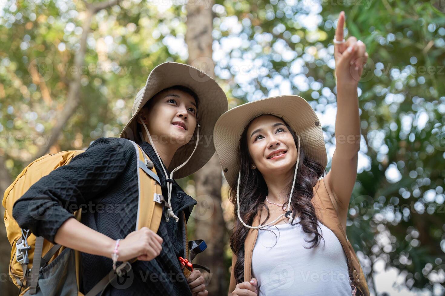 Lovely couple lesbian woman with backpack hiking in nature. Loving LGBT romantic moment in mountains photo