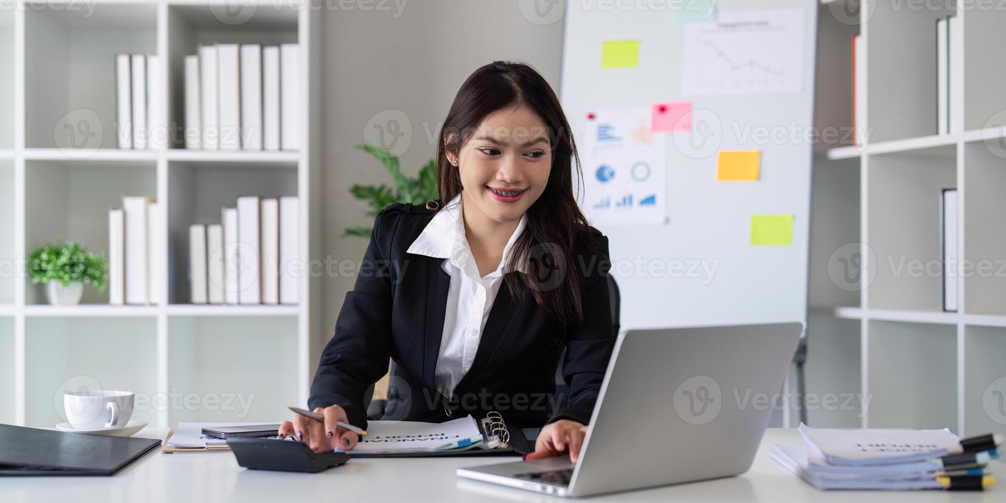 Businesswoman accountant using calculator and laptop for financial data saving in office room, Business financial, tax, accounting concept photo