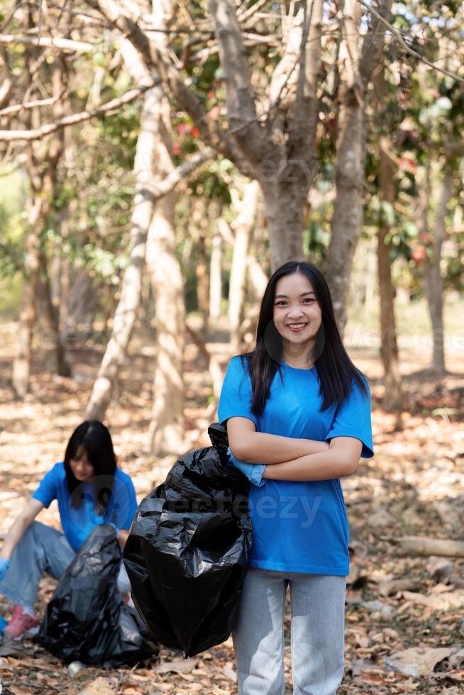 Volunteer collecting plastic trash in the forest. The concept of environmental conservation. Global environmental pollution. Cleaning the forest photo