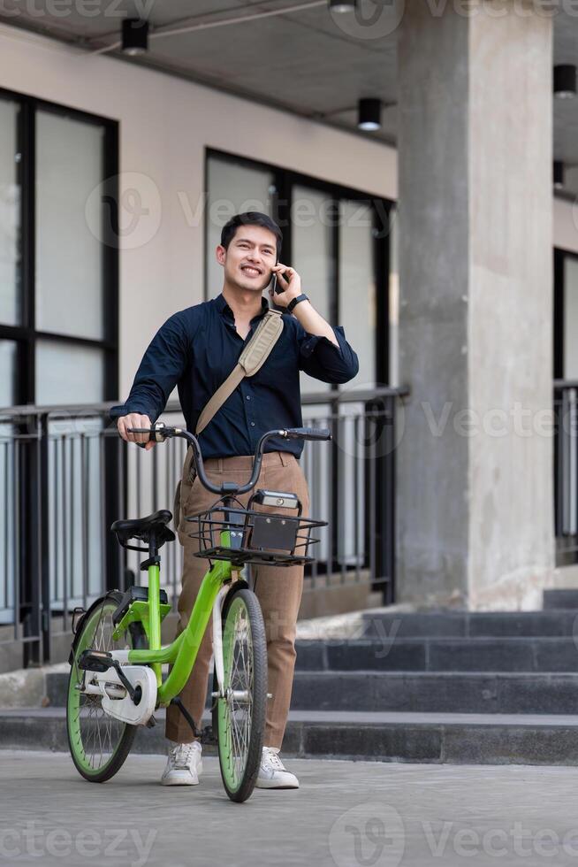 Eco friendly, Happy lifestyle asian young businessman ride bicycle go to office work at city street with bicycle in morning photo