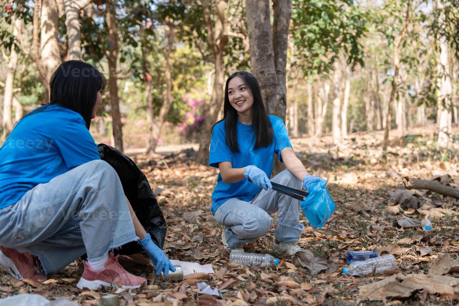 Young people friend volunteer collecting garbage plastic bottles to trash bags. environmental care ecology concept photo