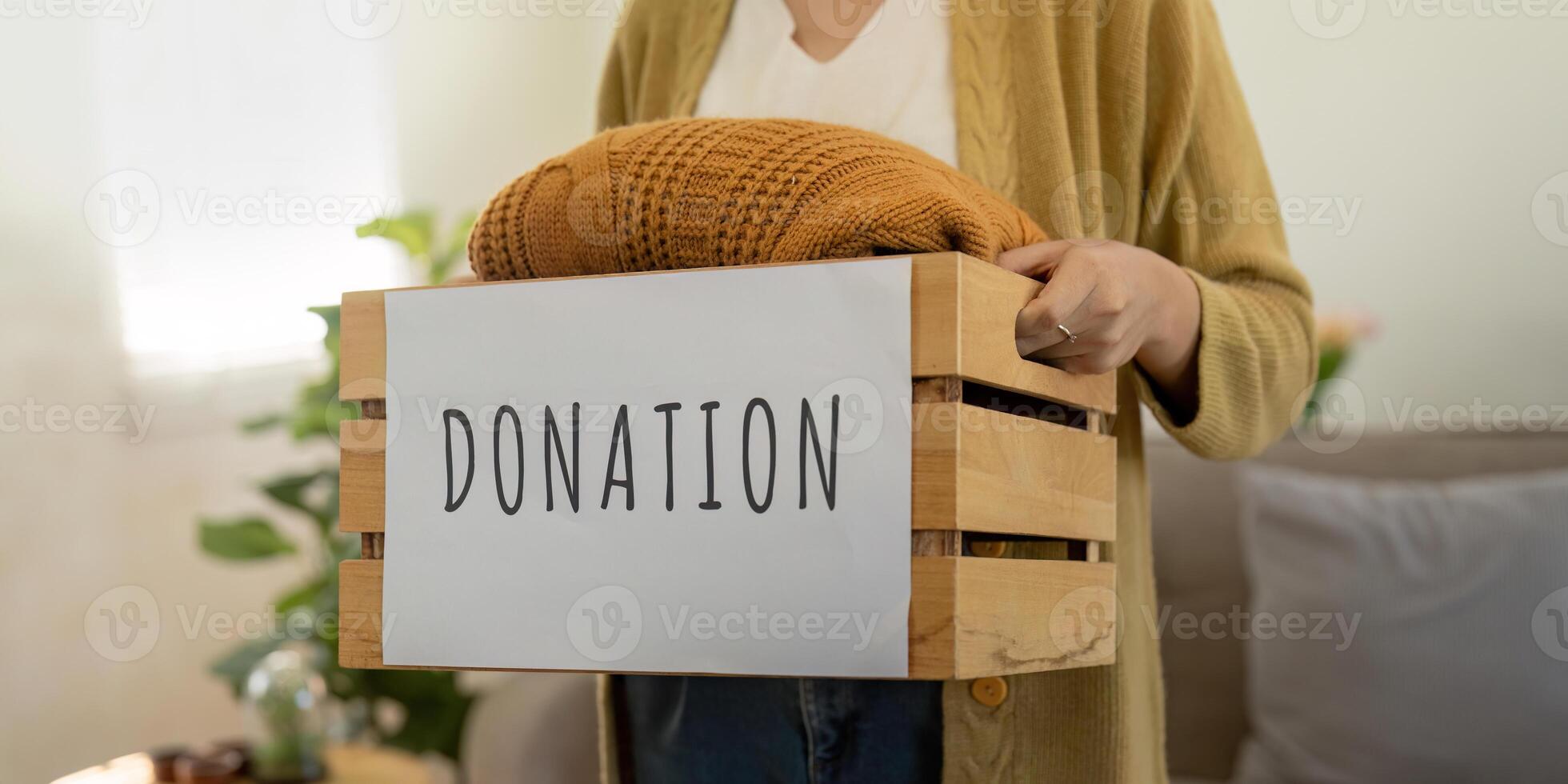 Donation, asian young woman sitting pack object at home, putting on stuff into donate box with second hand clothes, charity helping and needy people. Reuse recycle photo