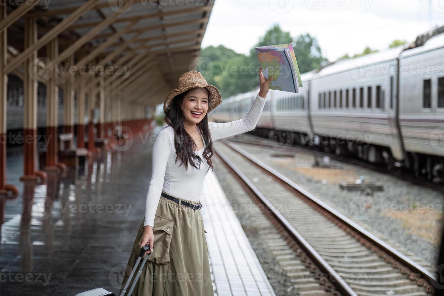 Alone Asian woman traveler with suitcase in train station platform. Summer vacation holiday and travel concept photo