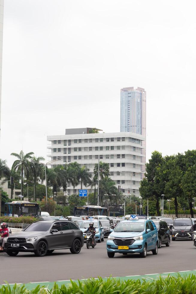 The area around Bundaran HI in Jakarta experiences high density, with public transportation, street vendors, and workers passing through, Jakarta, Indonesia, January 12nd 2022 photo