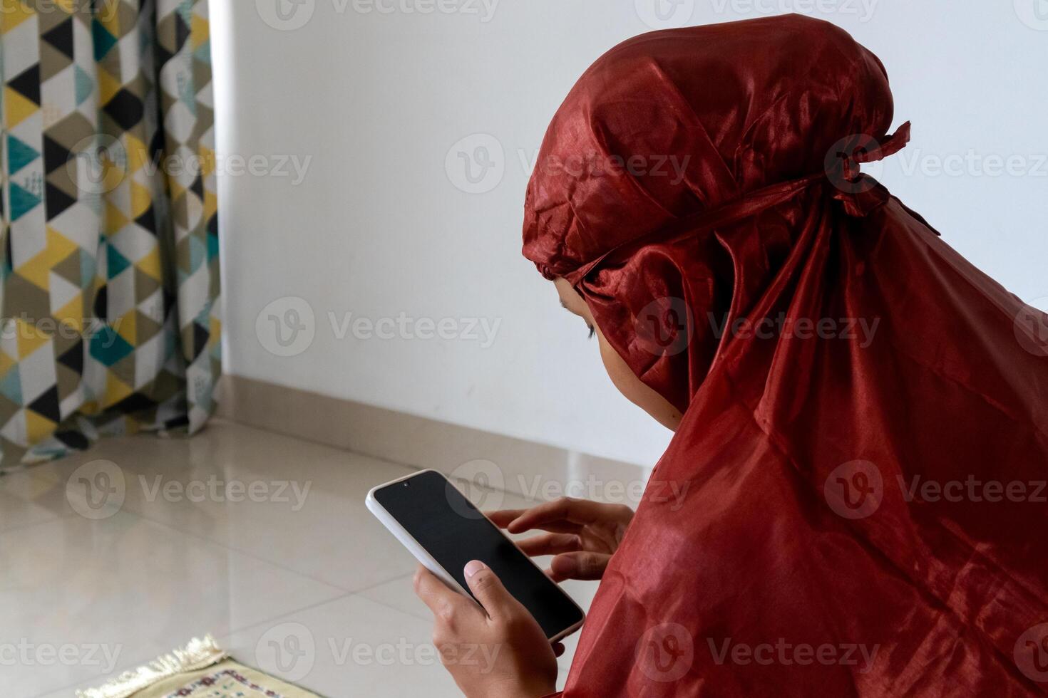 A muslim woman holding a smart phone and reading digital Quran on her smartphone photo