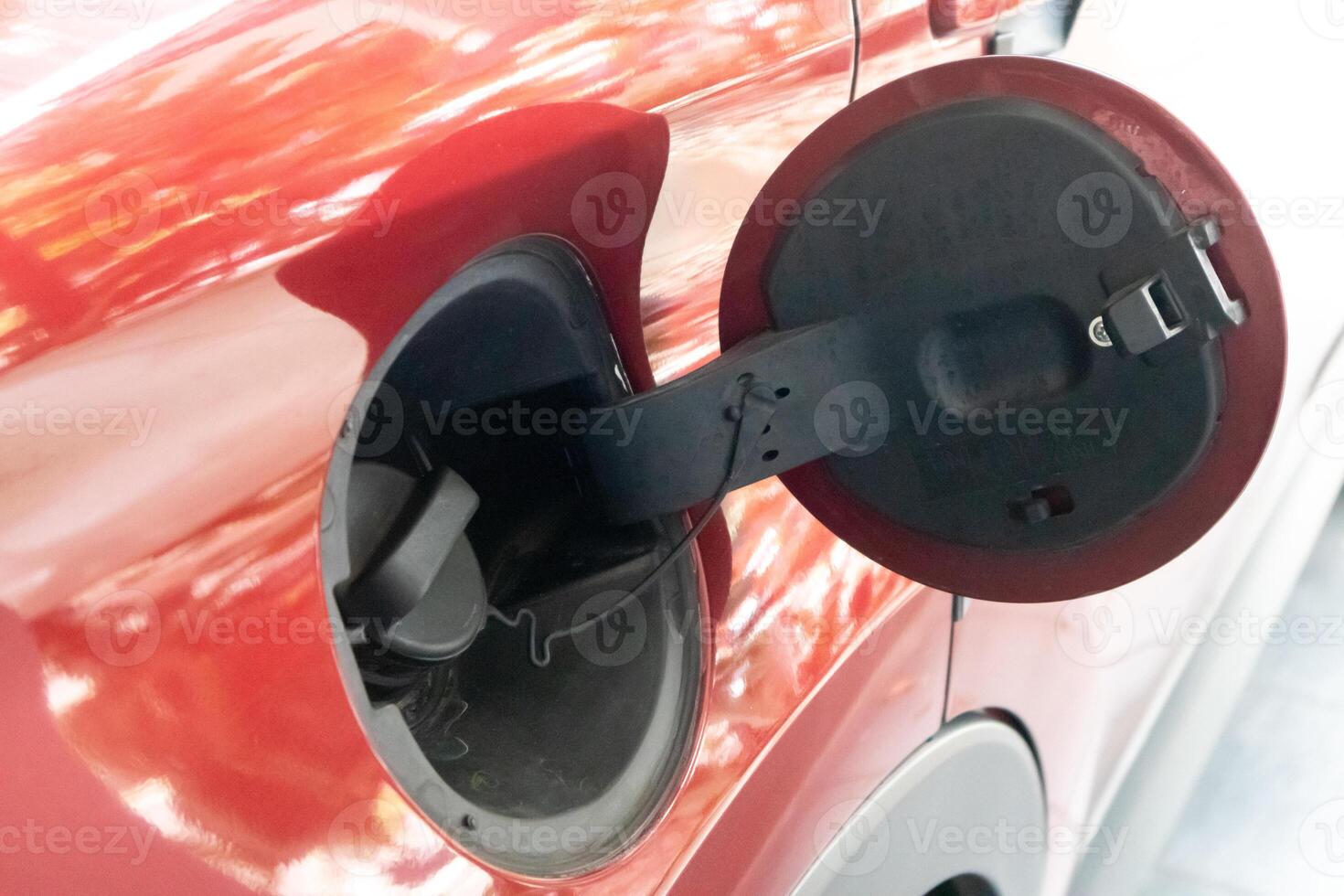 Close up view of the fuel tank cap cover on the red car. Open petrol cap cover. photo