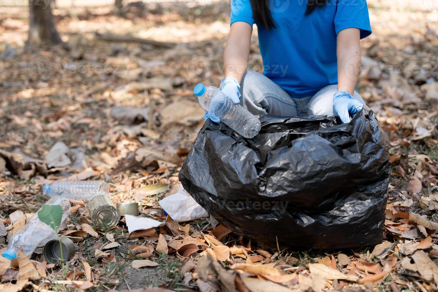 Young people friend volunteer collecting garbage plastic bottles to trash bags. environmental care ecology concept photo