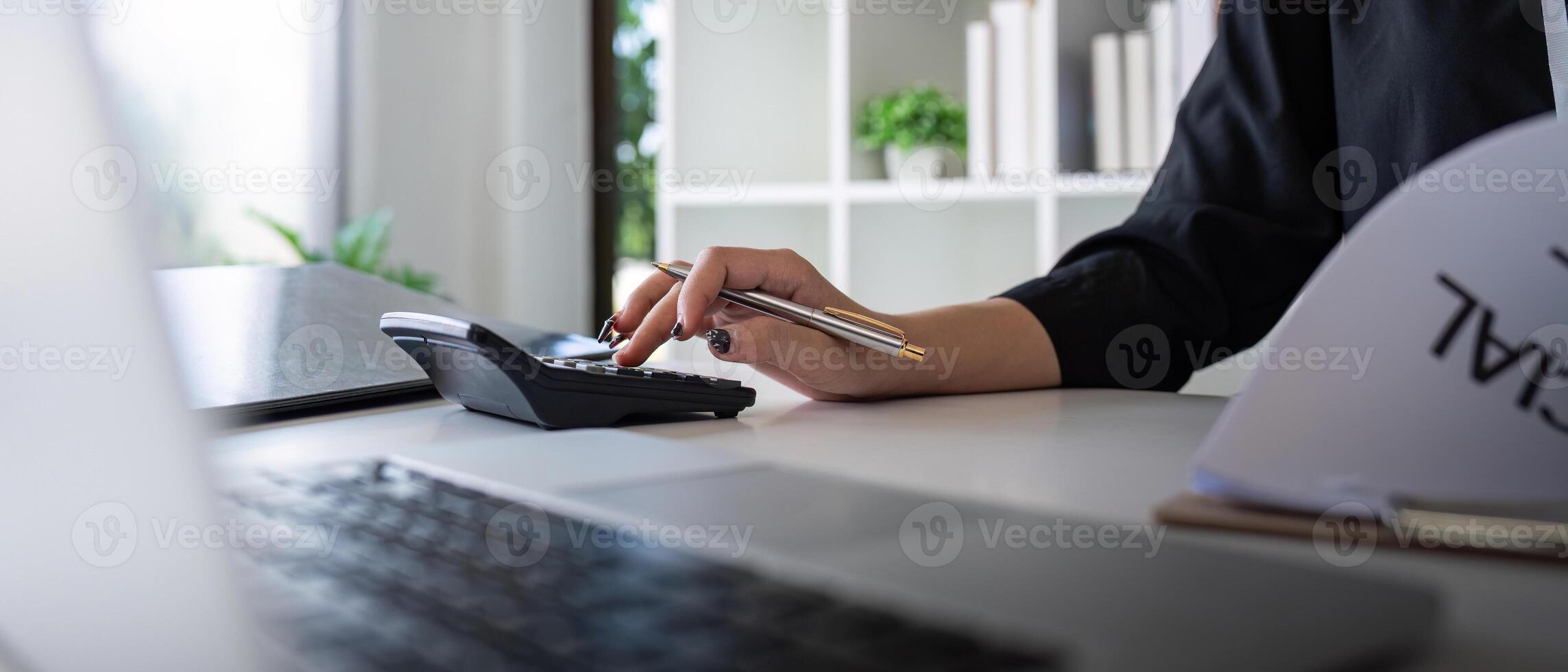 Businesswoman accountant using calculator and laptop for financial data saving in office room, Business financial, tax, accounting concept photo