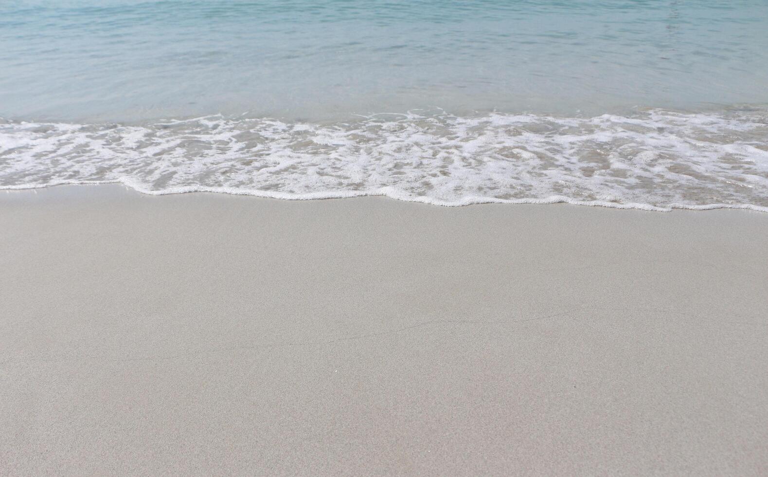 Ocean wave on sandy beach. Abstract background. photo