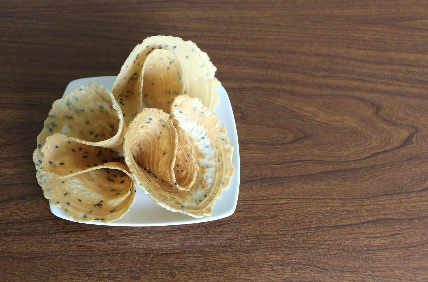 Tong Muan, traditional dessert in Thailand. Rolled wafer in plate on wooden table. photo