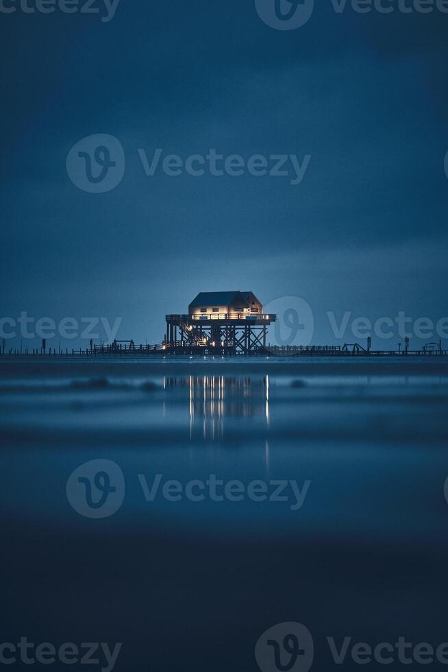 stilt house at sankt peter-ording germany at night photo