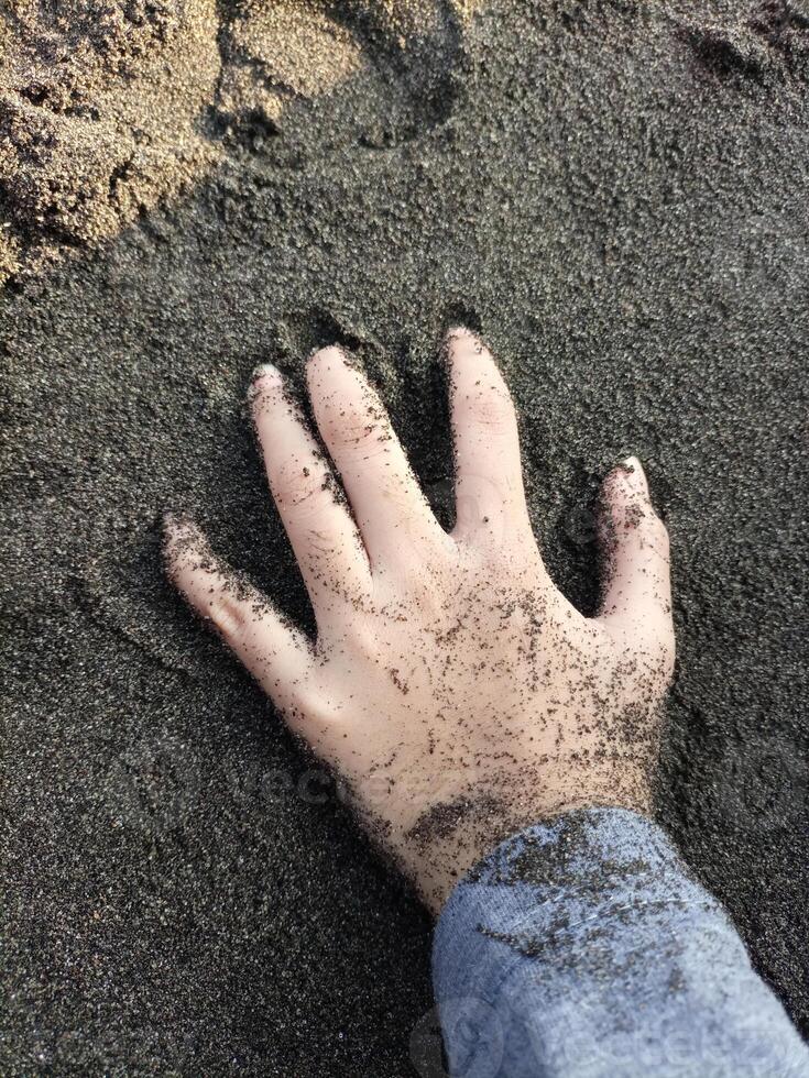 Kid playing in the sand on the beach photo