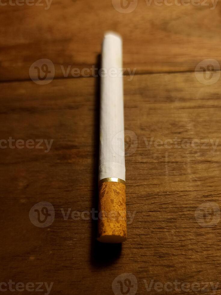 A filter cigarette on the wooden table photo