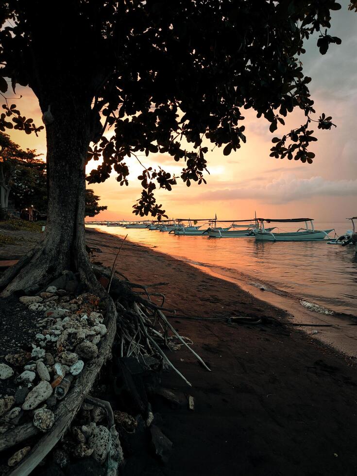 Fishing boats anchor on the beach in the afternoon, when the sunsets photo