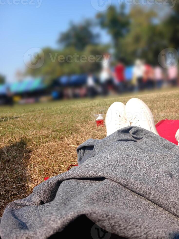 Woman wearing white sneakers sitting on the grass photo