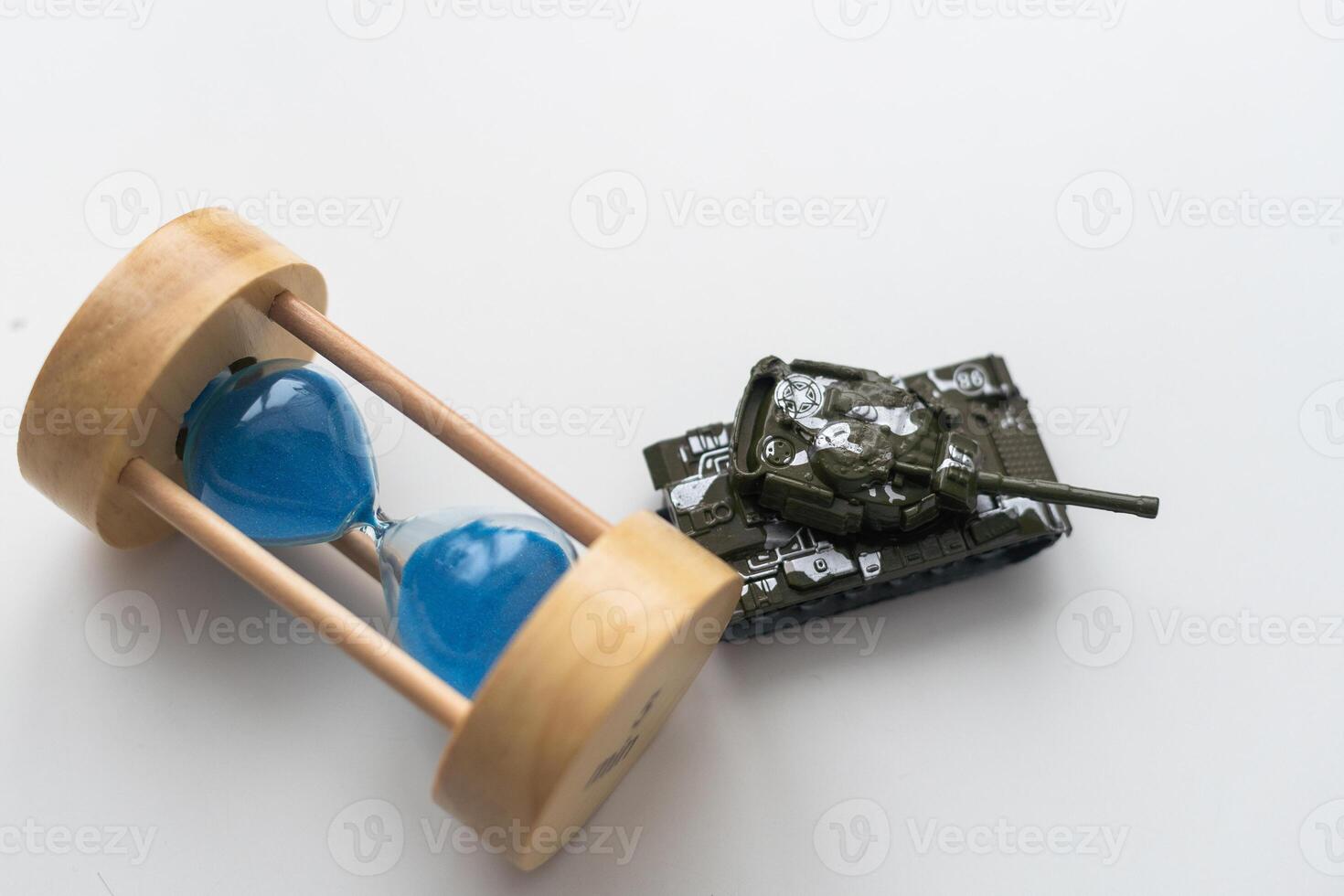 The plastic tank toys on the floor next to an hourglass photo