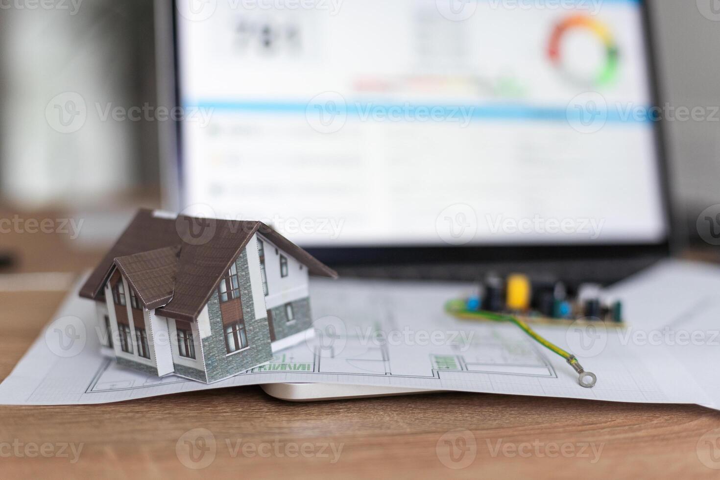 A real estate model and a computer are on the table. photo