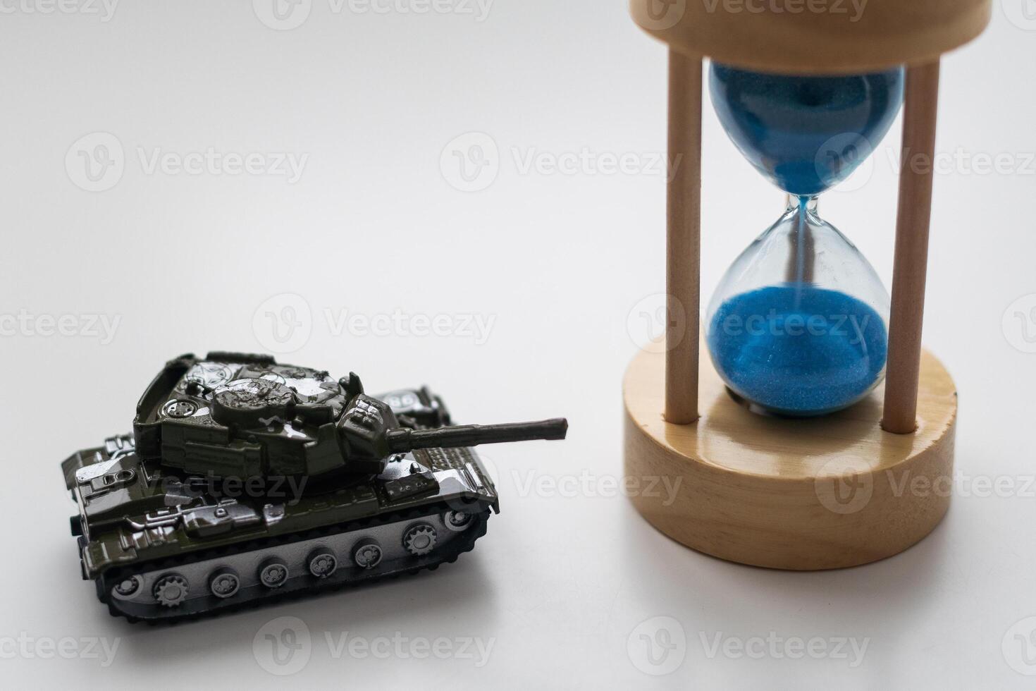 The plastic tank toys on the floor next to an hourglass photo