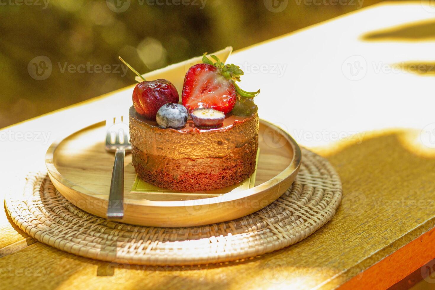 Chocolate Hazelnut Cake decorated with strawberry, raspberry, Blueberry,  and chocolate sauce. photo
