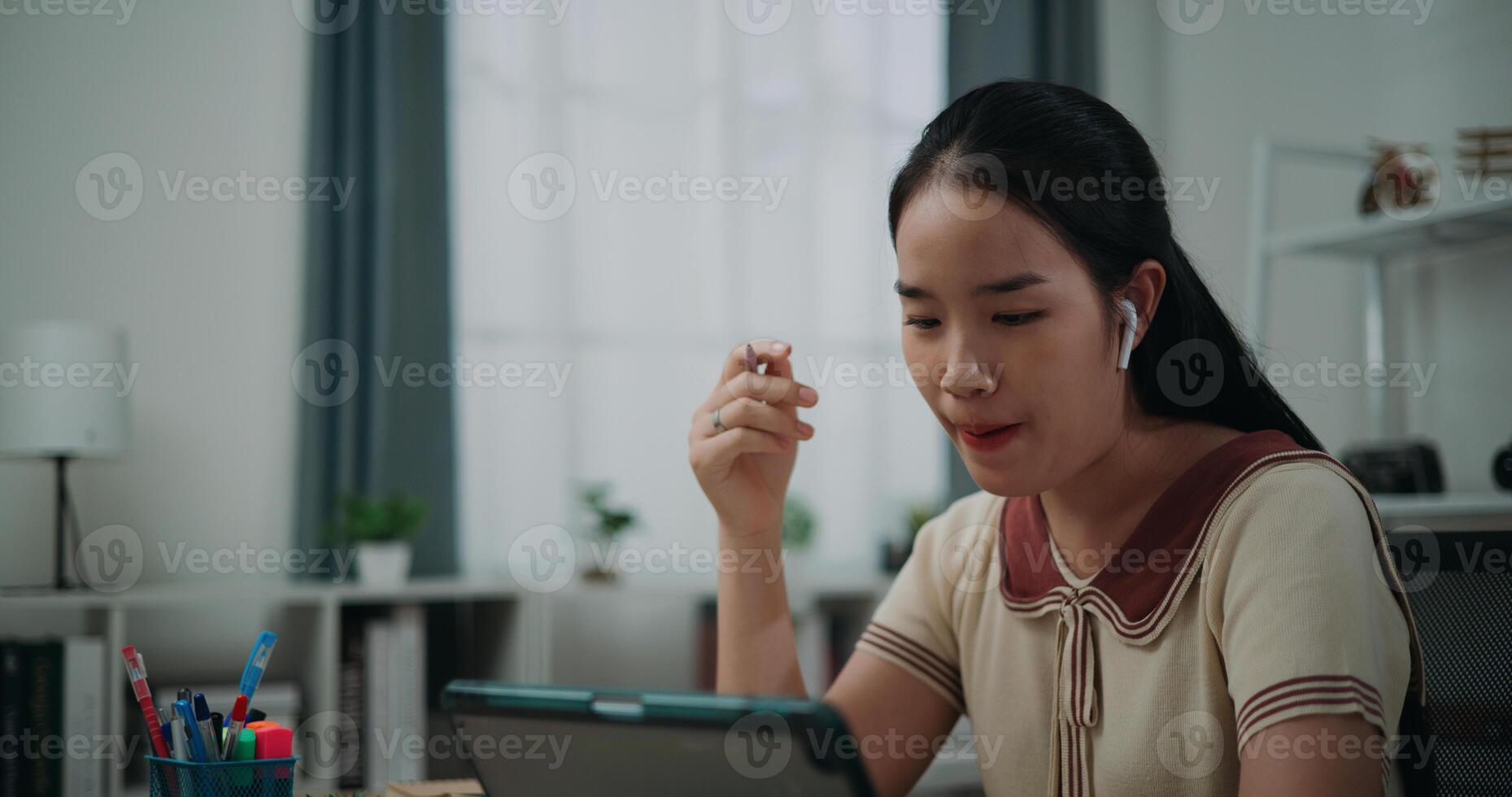 Selective focus, Side view,Female writer sitting at desk writing notes while working on tablet for online learning at home, creative thoughts to journaling, idea and inspiration photo