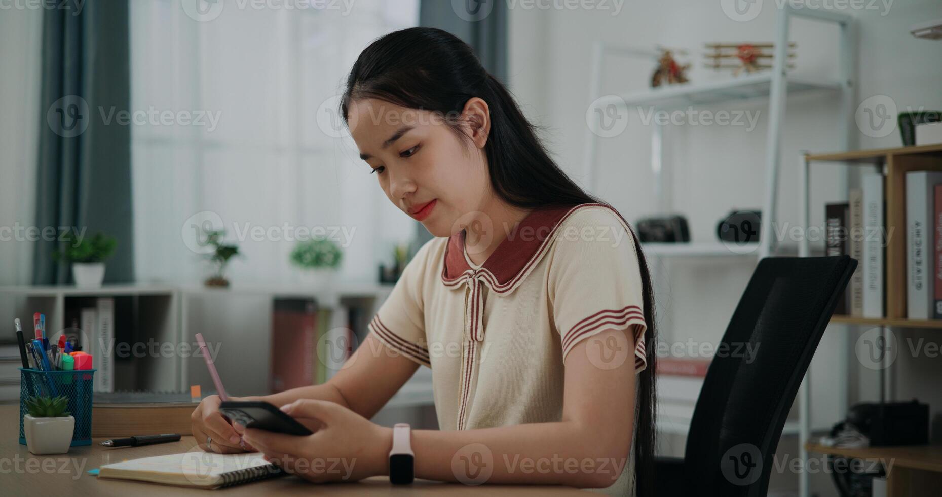 Side view, Female writer sitting at desk writing noting information to diary from smartphone at home, creative thoughts to journaling, idea and inspiration photo