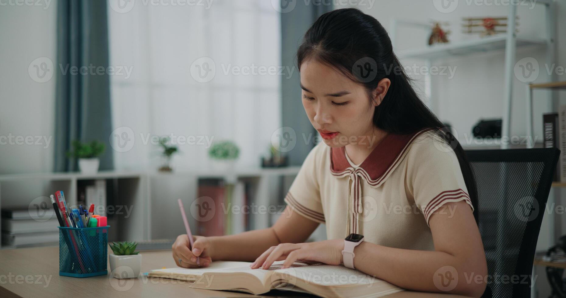 Selective focus, Female writer sitting at desk writing information on diary notebook while reading book at home, creative thoughts to journaling, idea and inspiration photo