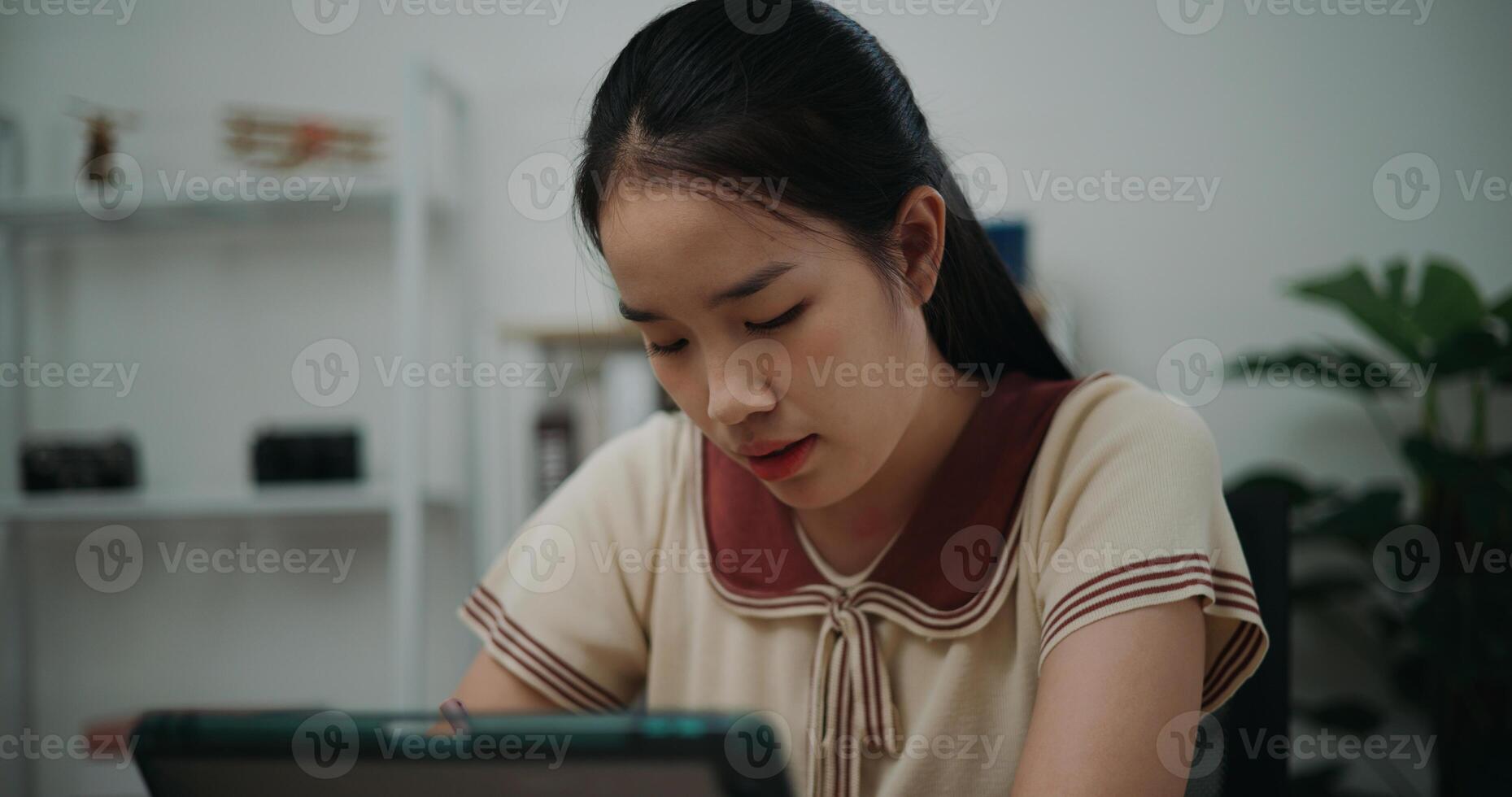 Selective focus, Front view,Female writer sitting at desk writing notes while working on tablet for online learning at home, creative thoughts to journaling, idea and inspiration photo