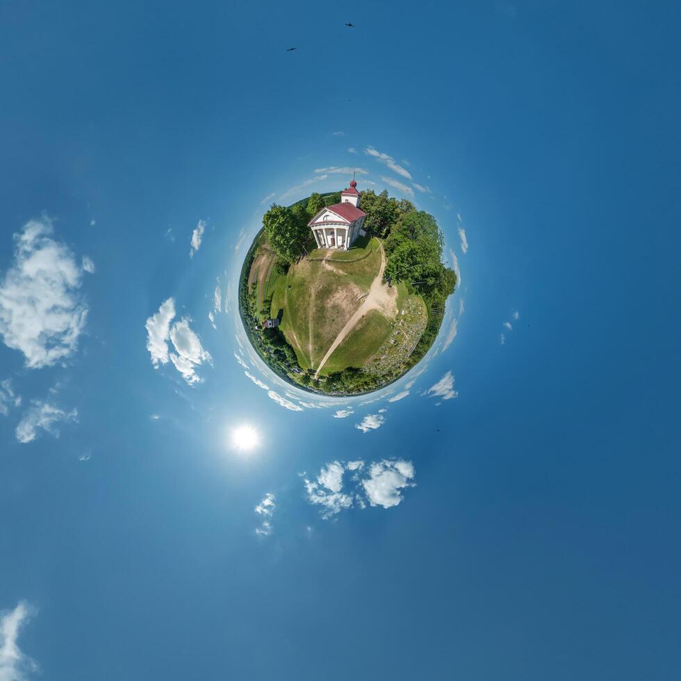 little planet transformation of spherical panorama 360 degrees overlooking church in center of globe in blue sky. Spherical abstract aerial view with curvature of space. photo